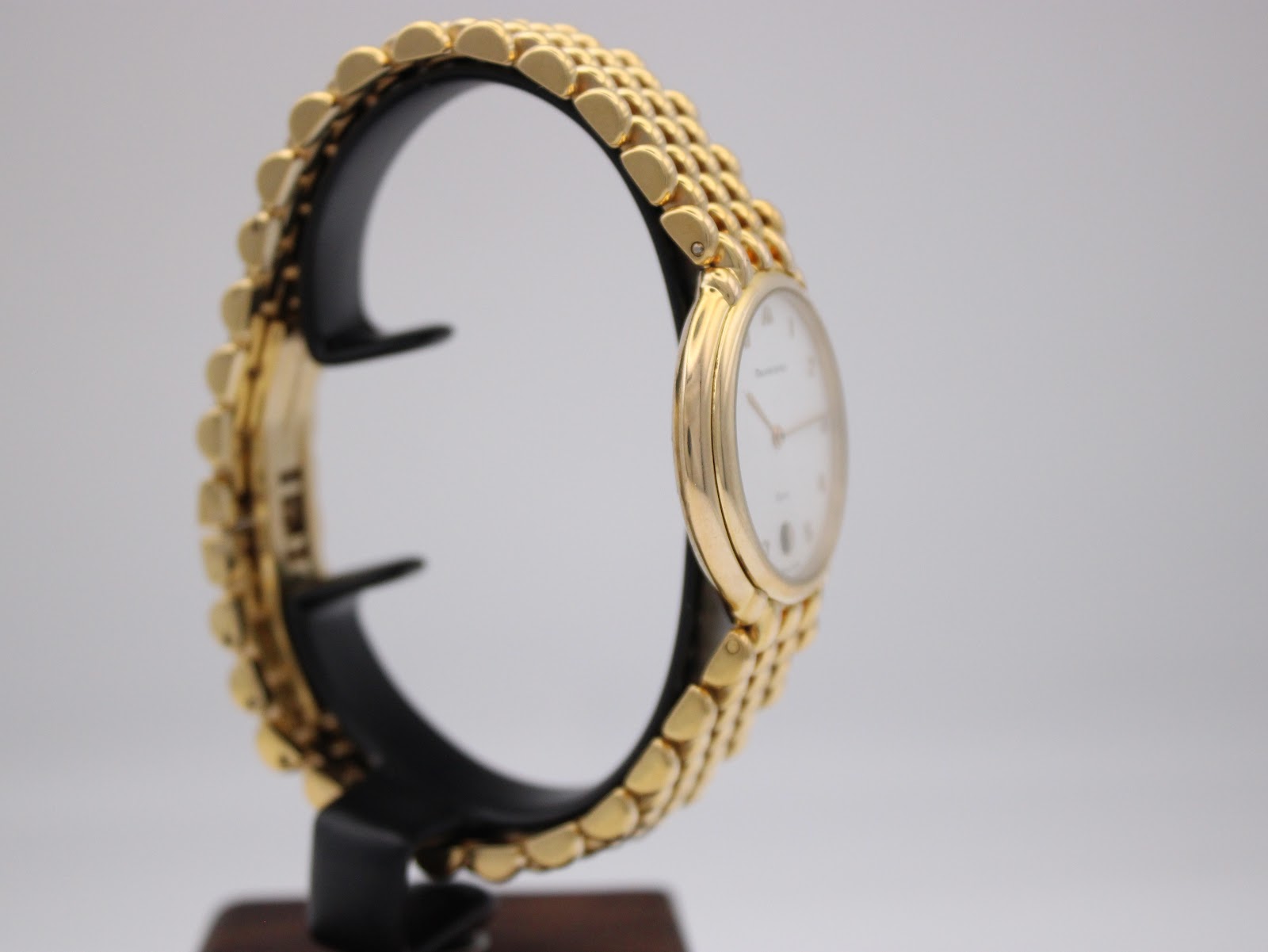 Another side view of the Maurice Lacroix watch on a display stand, showing the case profile and the gold electroplated bracelet.