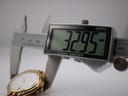 Digital caliper measuring the case diameter of the watch, displaying '32.95 mm'.