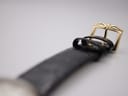 Close-up of the gold-tone pin buckle on the black leather strap, featuring a classic, elegant design.