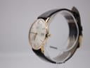 Side profile view of the Rotary watch on a display stand, highlighting the gold-plated case and original crown.