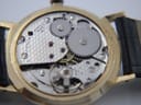 Detailed view of the Swiss Made manual wind mechanical movement with various gears, jewels, and the balance wheel visible.