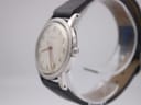 Side profile view of the Garrard watch on a stand, showing the stainless steel case, original crown, and domed acrylic crystal.