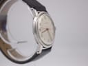 Angled side view of the Garrard watch, highlighting the lugs, case shape, and texture of the grey leather strap.