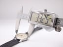 Digital caliper displaying a precise measurement of 33.25 mm across the Garrard watch case diameter.