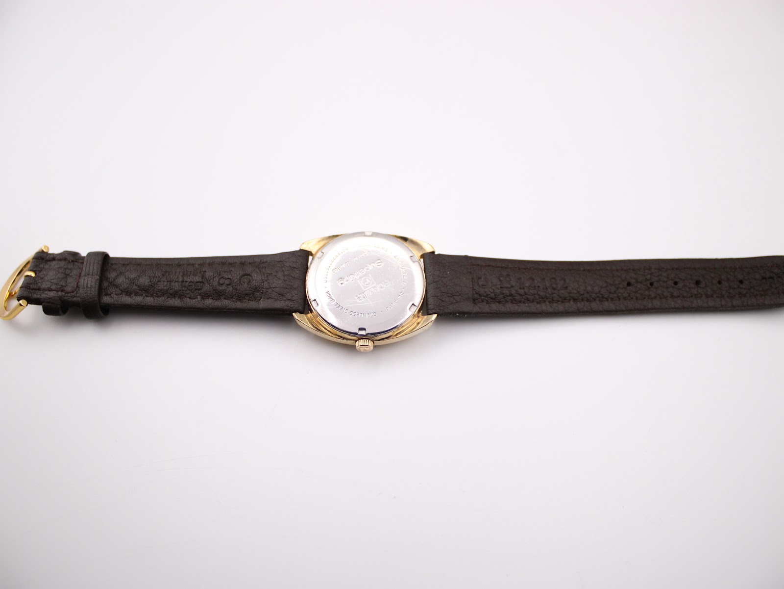 Full view of the Roamer Superking watch from the back, showing the case back and the dark brown leather strap laid flat.