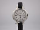 Front view of silver-toned Bulova Accutron watch with silver dial and black leather strap on a watch stand.