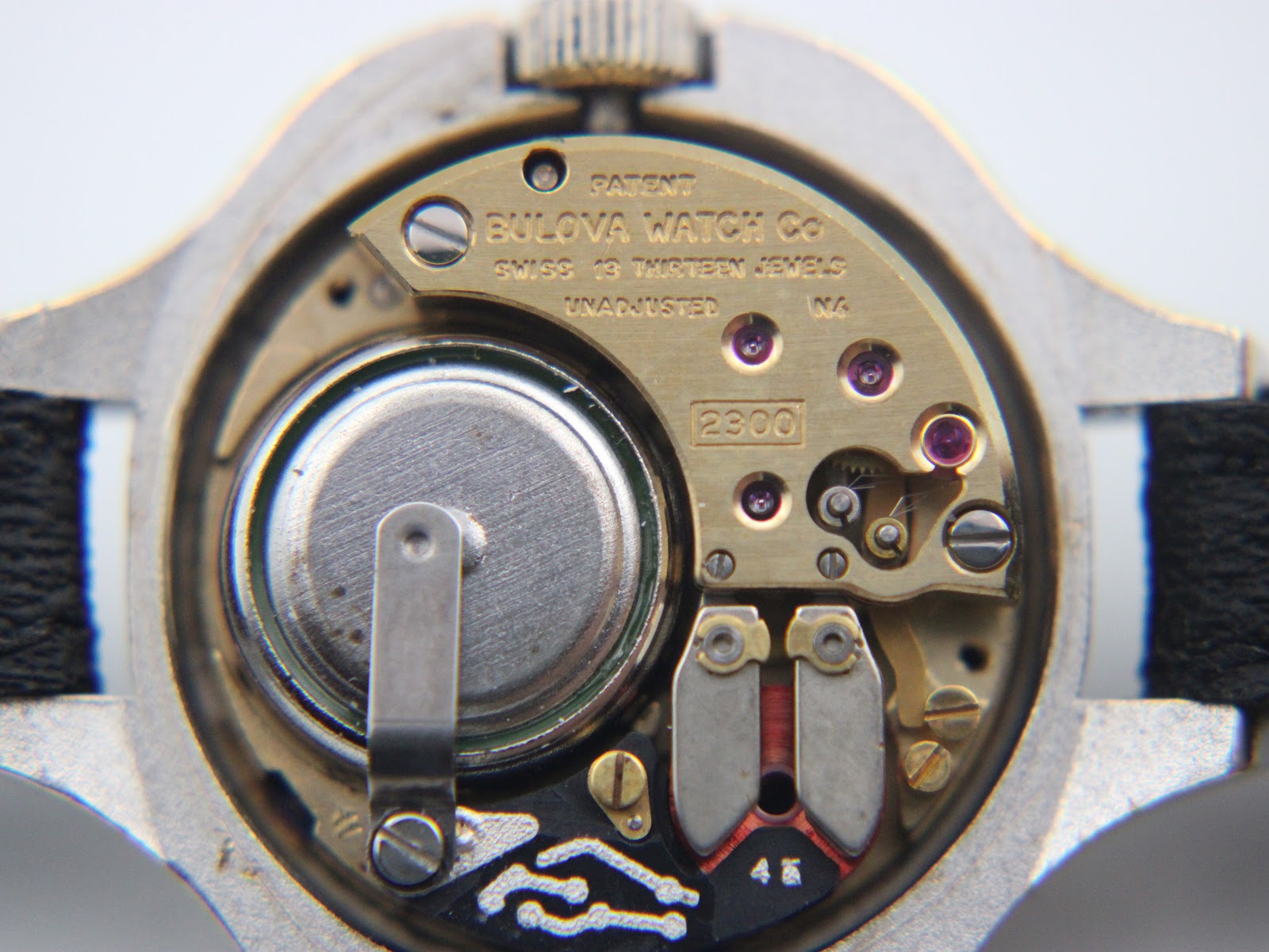 Close-up of the Bulova Accutron Cal. 2300 electric movement with 13 jewels and battery compartment visible.