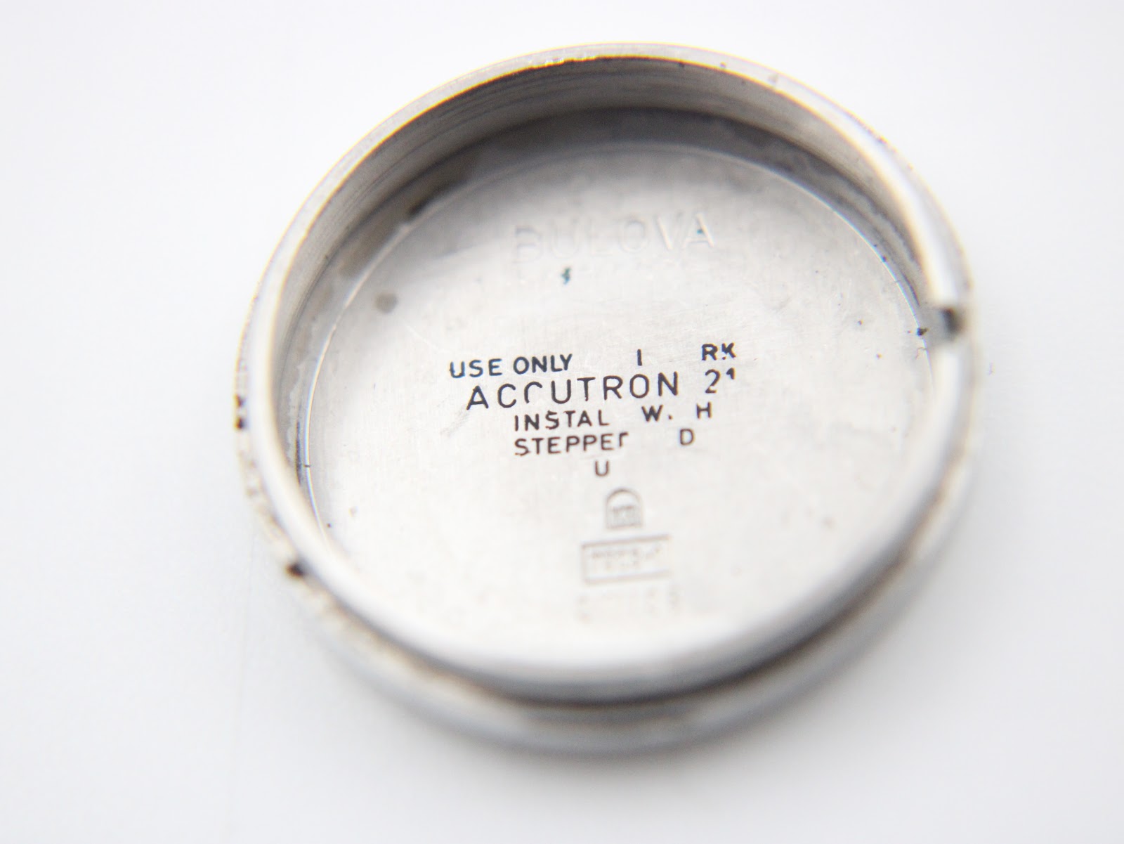 Inside view of the watch case back, showing "USE ONLY ACCUTRON" and other inscriptions.