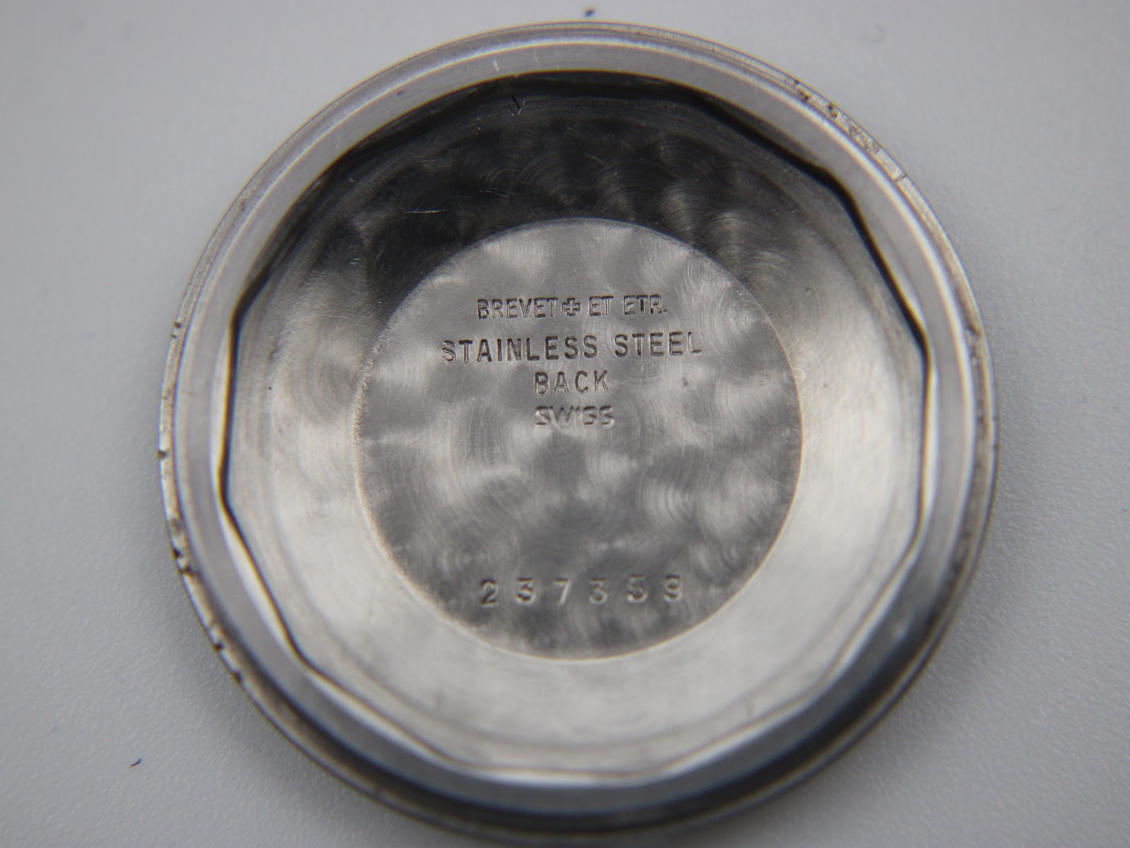Inside of the stainless steel case back, showing "BREVET & ET ETR. STAINLESS STEEL BACK SWISS" and serial number "237359".