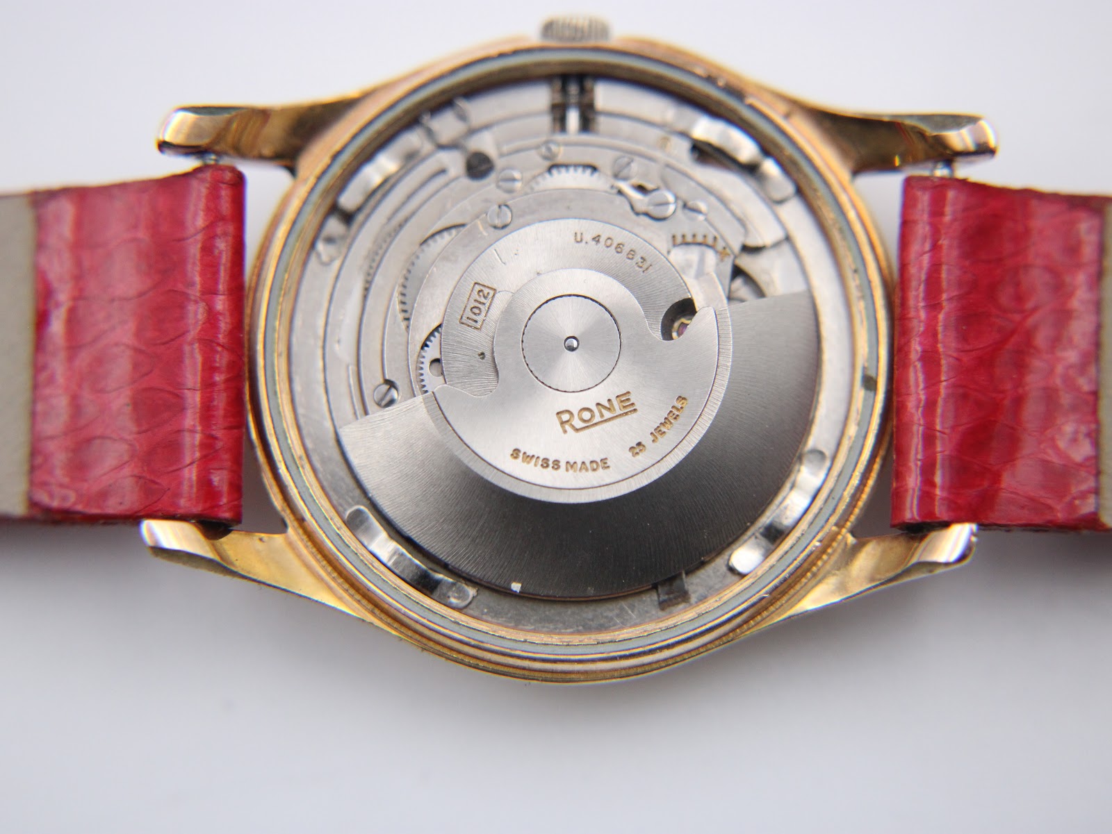 Open case back view showing the Swiss Rone automatic movement with "RONE SWISS MADE 25 JEWELS" engraved on the rotor, and the Incabloc shock protection.
