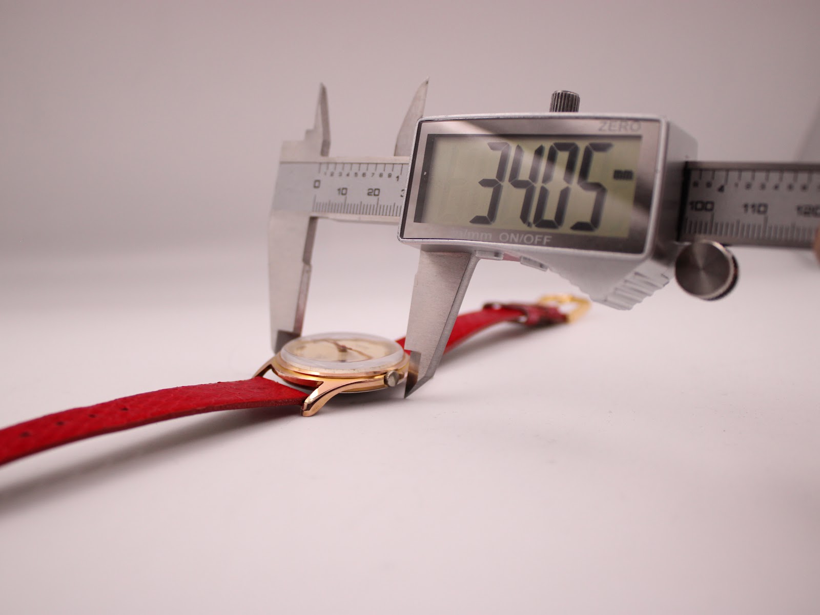 Close-up of a digital caliper measuring the case diameter of the watch, displaying "34.05".