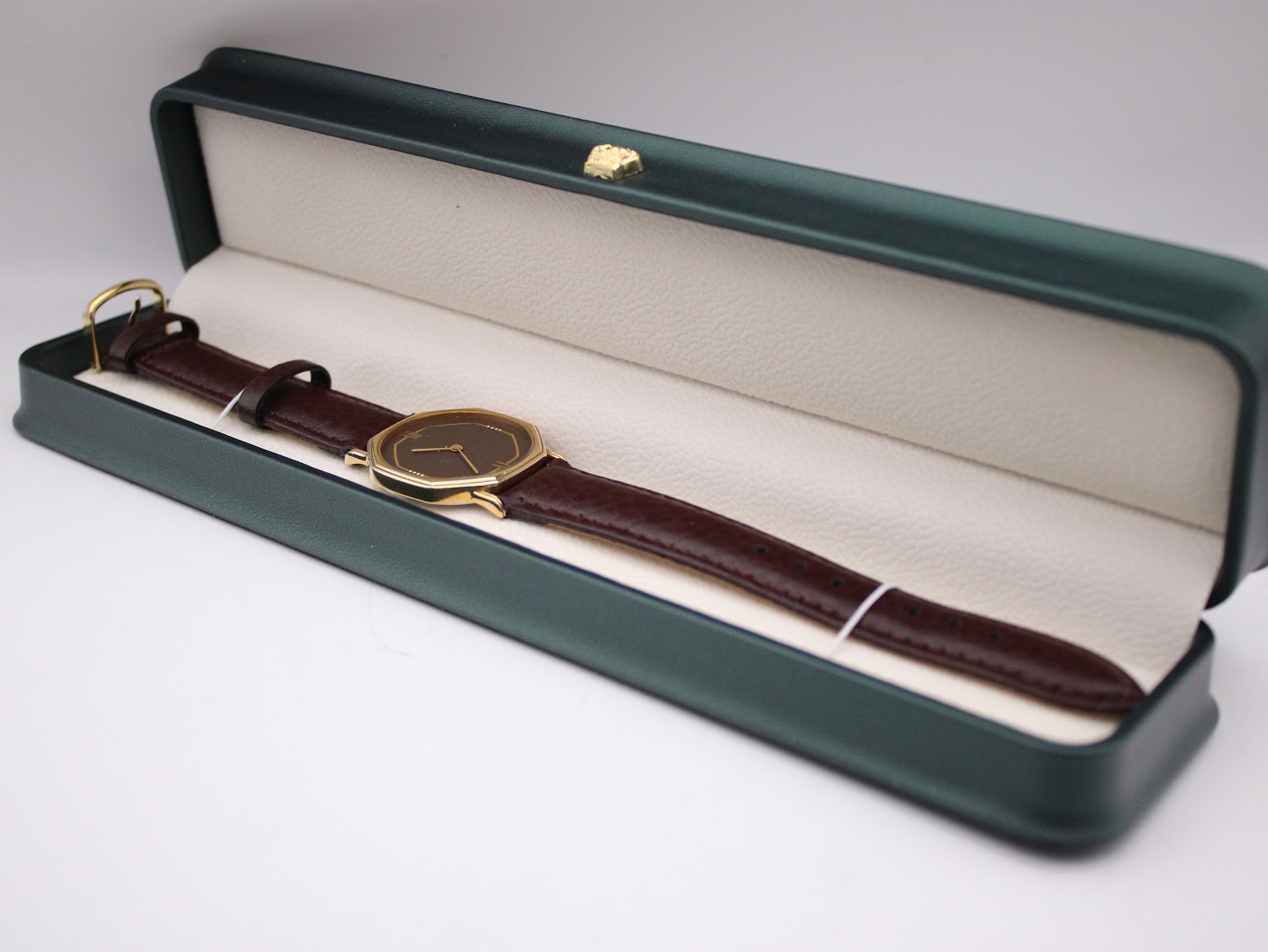 The Raymond Weil Genève watch presented neatly within a green jewellery box, highlighting its elegant display.