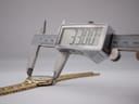 Digital caliper measuring the case diameter of the Raymond Weil watch, displaying 33.00mm.