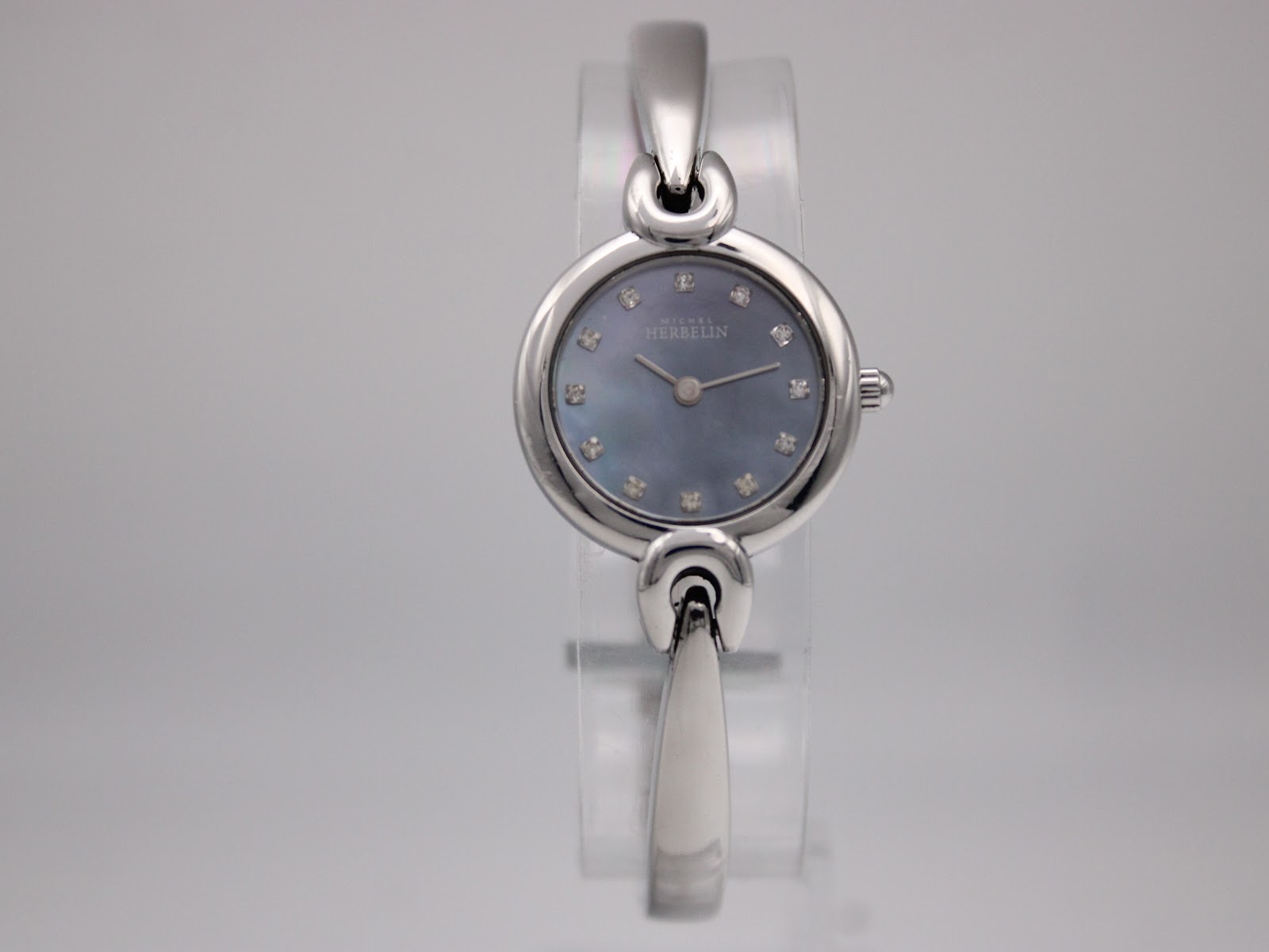 Straight-on front view of the Michel Herbelin watch, showcasing the blue dial with diamond hour markers.