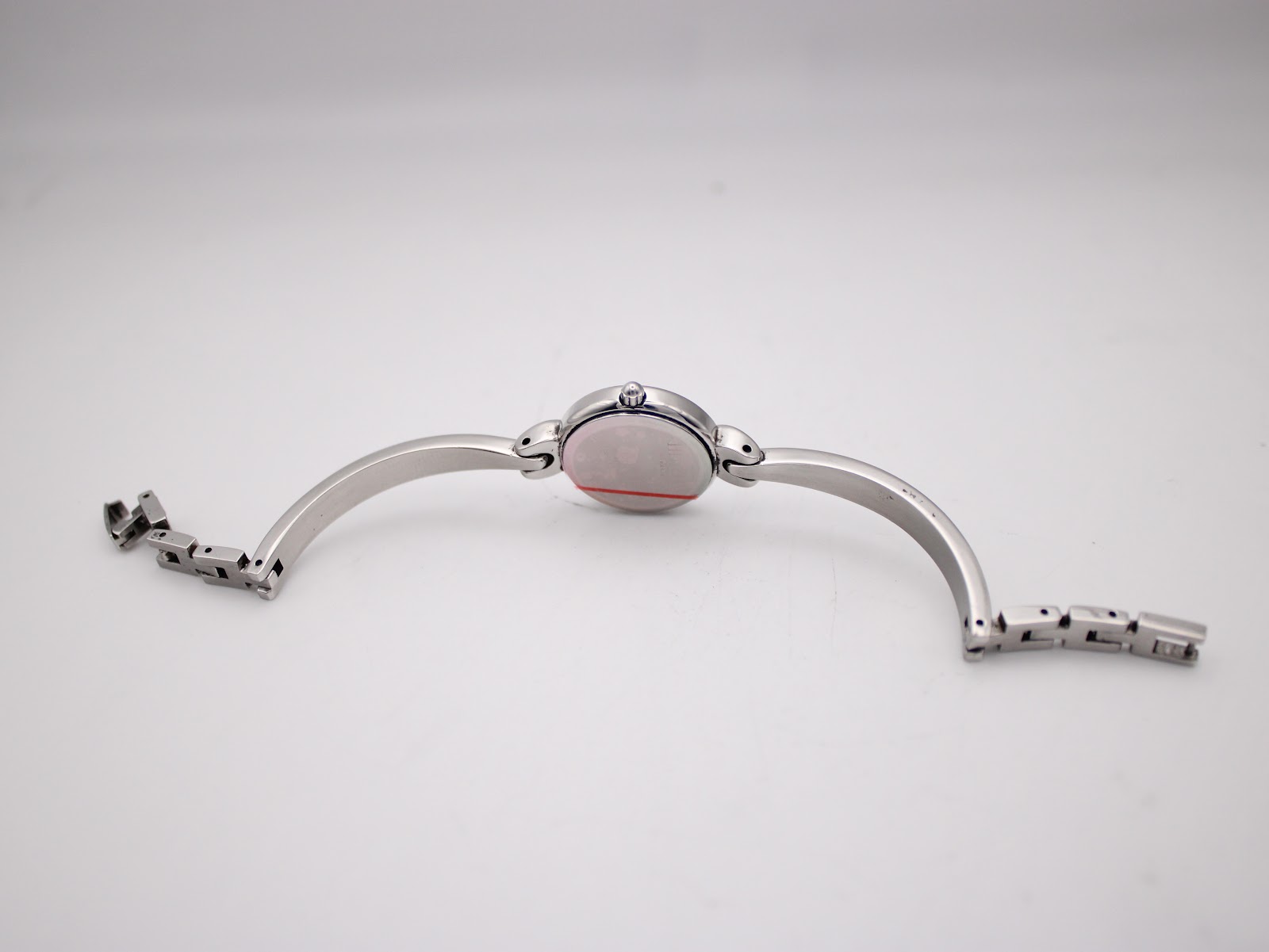 Back view of the Michel Herbelin watch lying flat, revealing the integrated bangle bracelet construction.