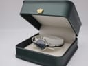 Michel Herbelin watch displayed inside an open dark green presentation box with a gold crown emblem.