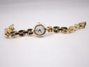 Full length top-down view of the Michel Herbelin Paris watch laid flat, displaying the entire gold-plated integrated bracelet and the small round watch head.