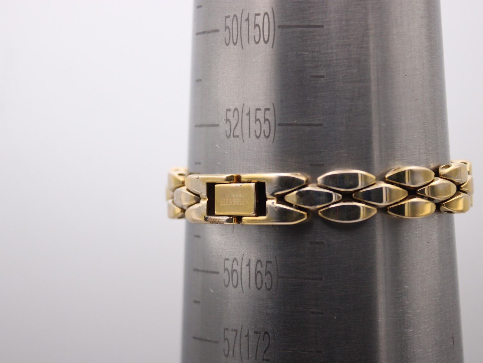 Close-up of the Michel Herbelin bracelet clasp on a wrist sizing cone, showing the signed 'Herbelin' clasp and the bracelet's length fitting around 165mm (approx 16cm).