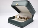Michel Herbelin ladies watch displayed inside a dark green watch box with a gold crown detail on the lid, showcasing the watch and bracelet.