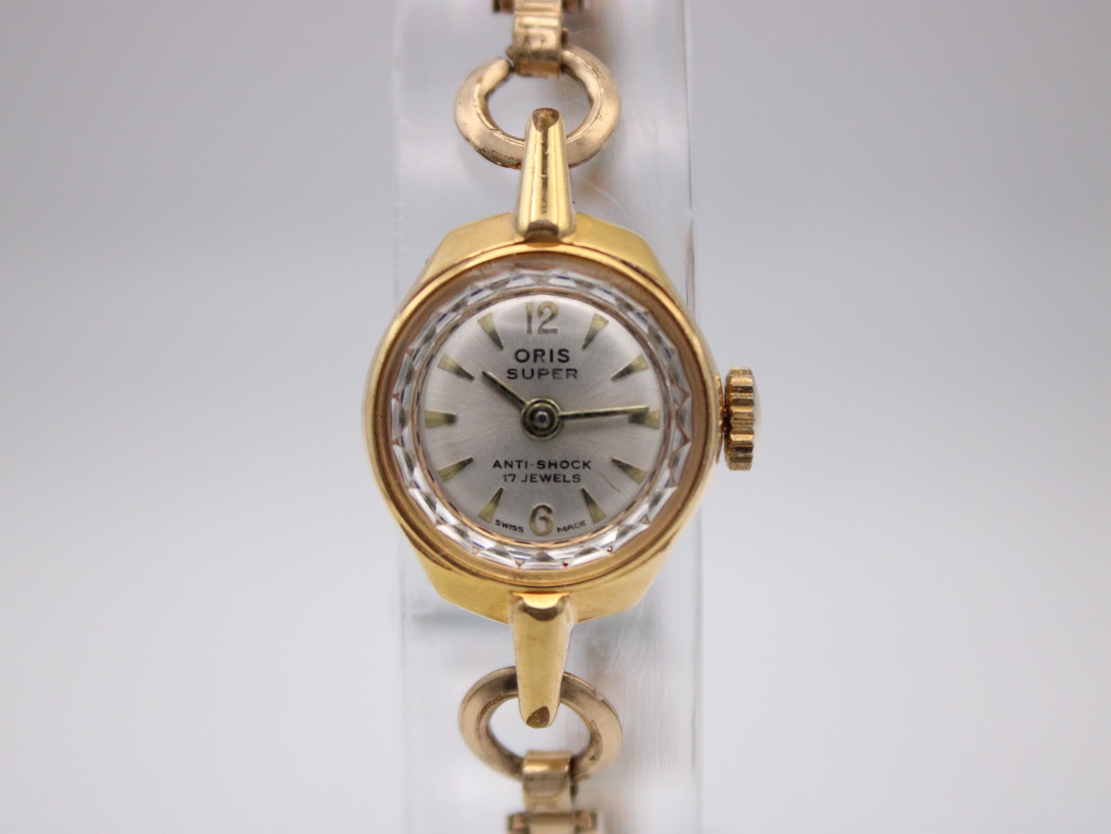 Close-up front view of Oris Super dial, showing Arabic 12 and 6 markers and faceted crystal.