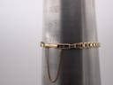 Gold integrated bracelet with safety chain on a wrist sizing gauge, showing 17.2cm measurement.