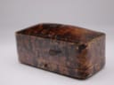 Closed view of the vintage brown presentation box with a textured, aged exterior.