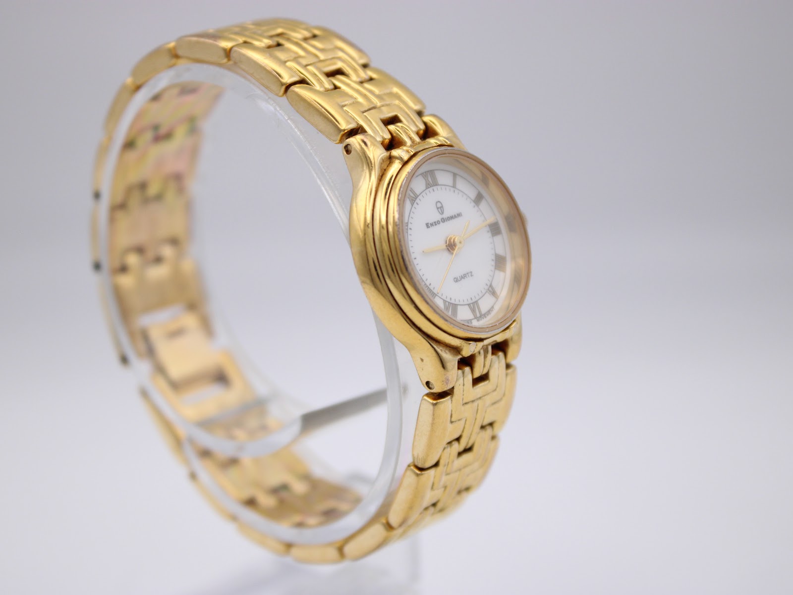 Another angled side view of the gold Enzo Giovanni watch on a display stand, highlighting the bracelet design.