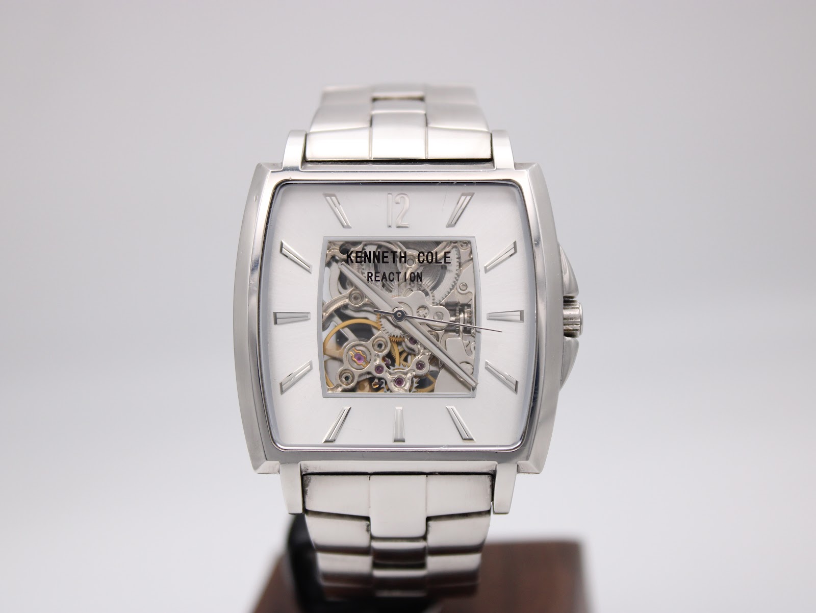 Full front view of the Kenneth Cole Reaction automatic skeleton watch, displaying the dial and bracelet.