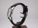 Side profile view of the Emporio Armani AR-0413 watch on a stand, highlighting the polished stainless steel case and crown.
