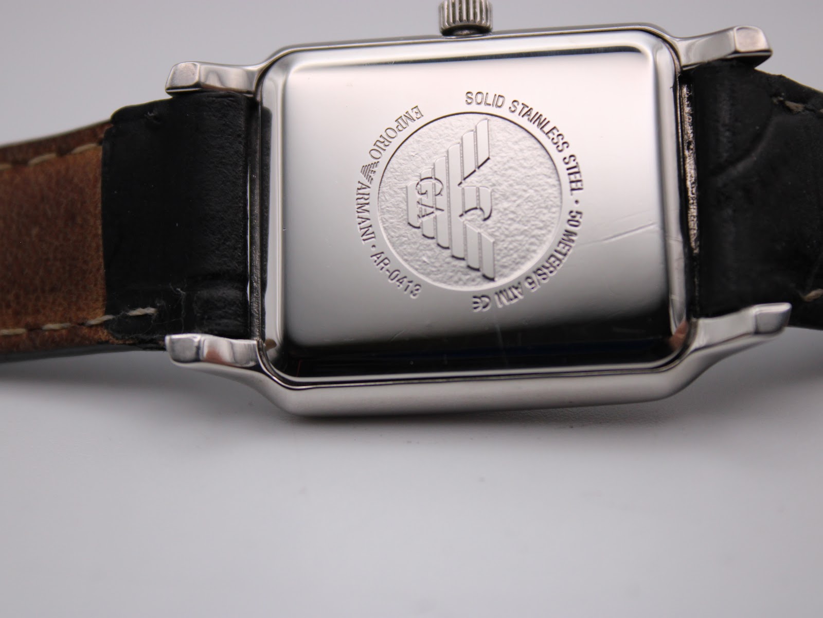 Close-up of the stainless steel case back of the Emporio Armani AR-0413, showing engravings for brand, model, and water resistance.