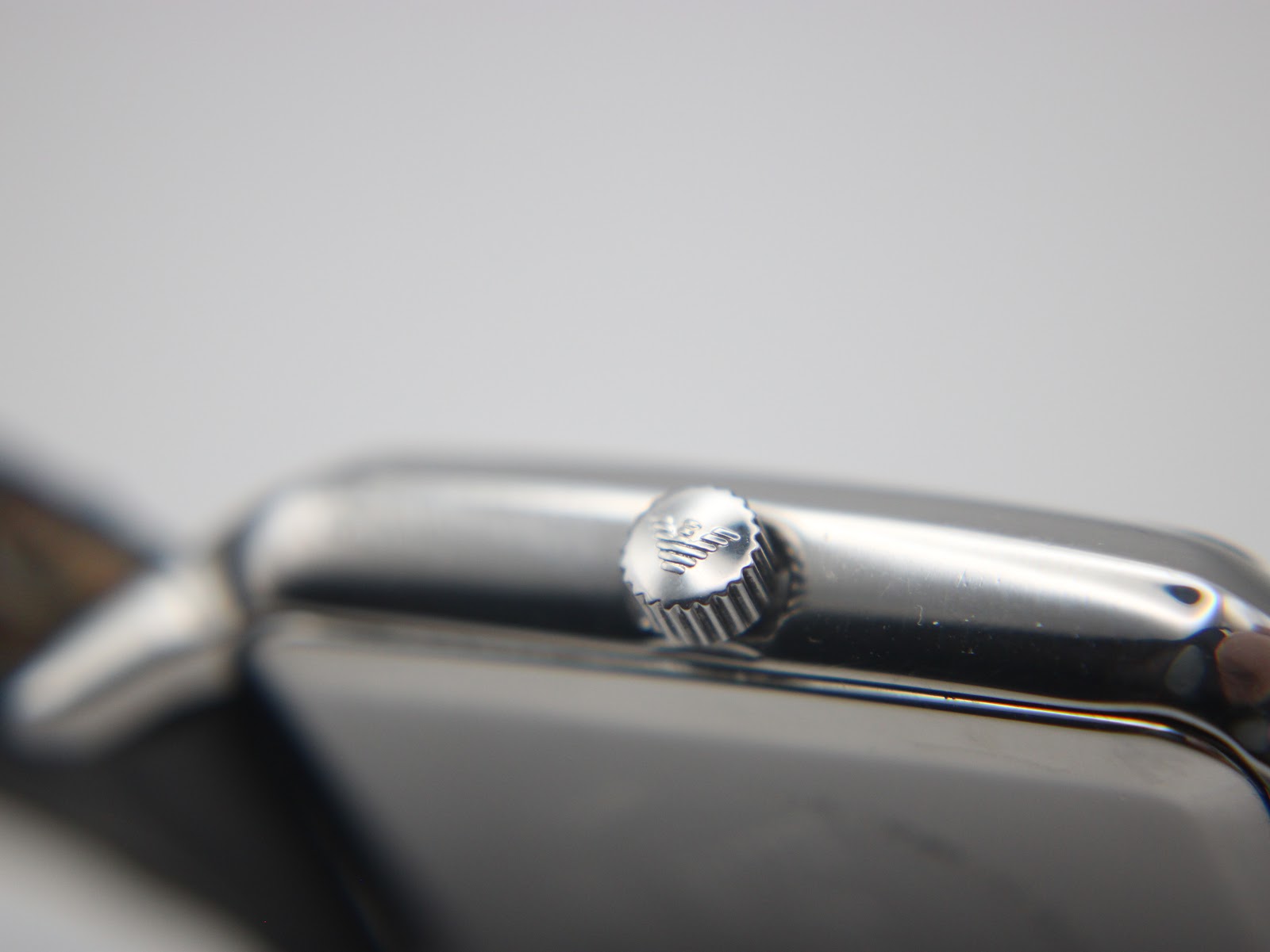 Detailed close-up of the push/pull crown on the Emporio Armani AR-0413, featuring the etched Emporio Armani eagle logo.