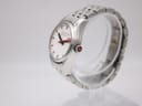 Side view of the Mondaine watch showing the polished stainless steel case and bracelet, with the red-detailed crown visible.