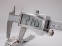Digital caliper measuring the watch case diameter, with the display clearly showing a measurement of 27.5mm.