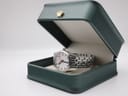 Mondaine watch nestled inside a deep green presentation box, highlighting its clean aesthetic.