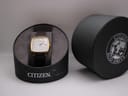 Watch inside its original Citizen Eco-Drive presentation box, with box lid next to it.