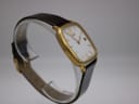 Another angled side view of the gold-plated Citizen watch on a display stand, showing the slim case profile.