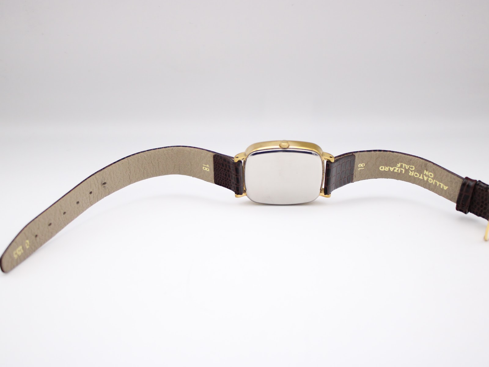 Rear view of the Citizen watch with strap laid flat, showing the plain case back and "18" stamped on the strap.