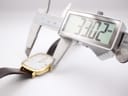 Digital caliper measuring the watch case width, displaying 33.02 mm.