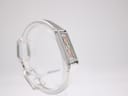 Left-side view of the Gucci 1500L watch on a display stand, showcasing the sleek lines of the stainless steel bangle bracelet and case.