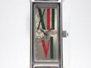 Close-up front view of the Gucci 1500L dial, clearly showing the green and red Roman numerals XII and VI, the Gucci logo, and the subtle floral background pattern.