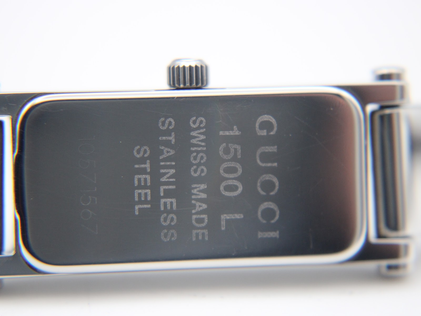 Close-up of the case back of the Gucci 1500L, revealing engravings: "GUCCI", "1500 L", "SWISS MADE", "STAINLESS STEEL", and a serial number "10671567".