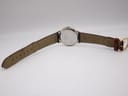 Rear view of the watch on a white background, showing the full length of the two-tone leather strap and gold-tone buckle.