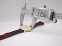 A digital caliper measuring the case diameter of the Roamer watch, displaying an exact measurement of 33.90mm.