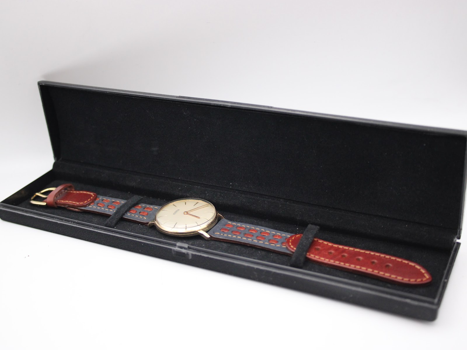 The Roamer watch nestled in an open black presentation box, showing the watch and strap clearly within the case.