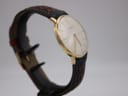 Another side angled view of the gold plated Roamer watch, clearly showing the unsigned crown and the curvature of the crystal.