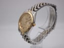 Angled side view of the Bulova Super Seville showing the fluted gold-tone bezel, two-tone bracelet, and signed crown on a clear watch stand.