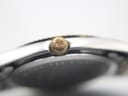 Extreme close-up of the gold-tone crown, showing the Bulova tuning fork logo.