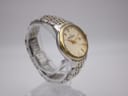 Another angled side view of the watch on a stand, highlighting the bracelet.