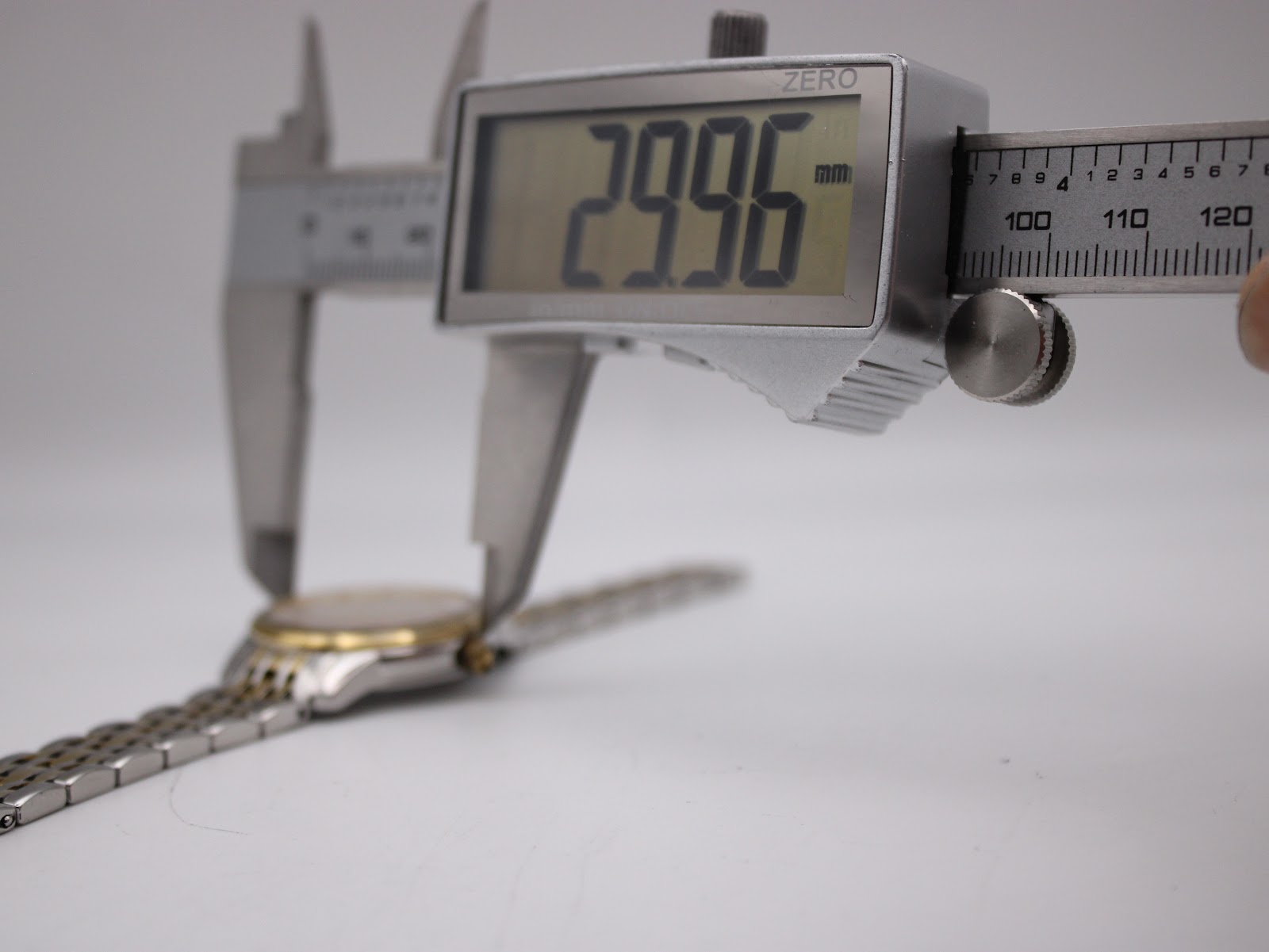 Digital caliper measuring the watch case diameter at 29.96mm.