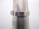 The two-tone bracelet on a wrist sizing cone, showing a circumference of approximately 145mm.